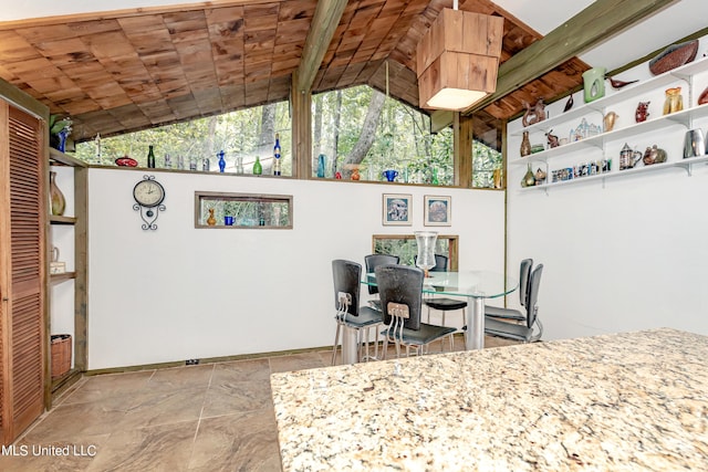 dining space with stone finish floor, vaulted ceiling, baseboards, and wooden ceiling