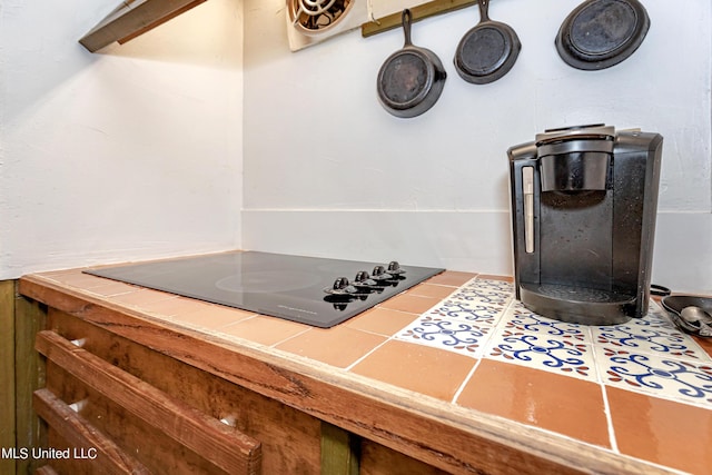 room details featuring tile countertops and black electric stovetop