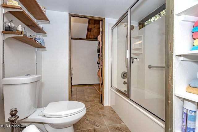 bathroom featuring toilet and shower / bath combination with glass door