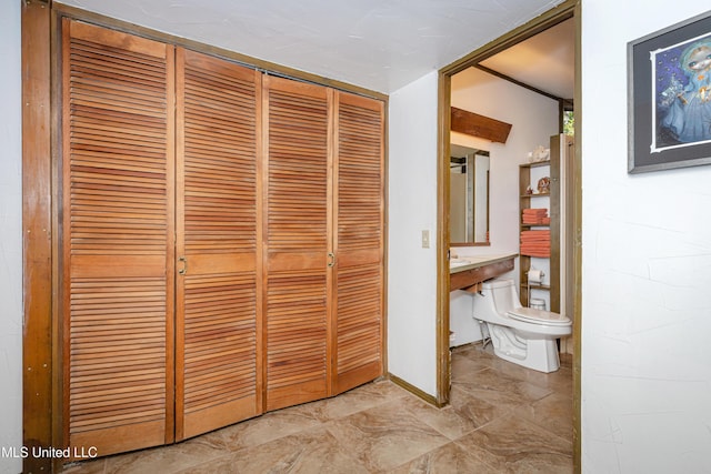 bathroom with marble finish floor, a closet, and toilet