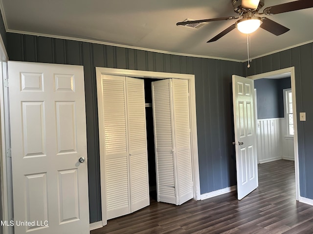 unfurnished bedroom featuring ornamental molding, dark hardwood / wood-style floors, a closet, and ceiling fan