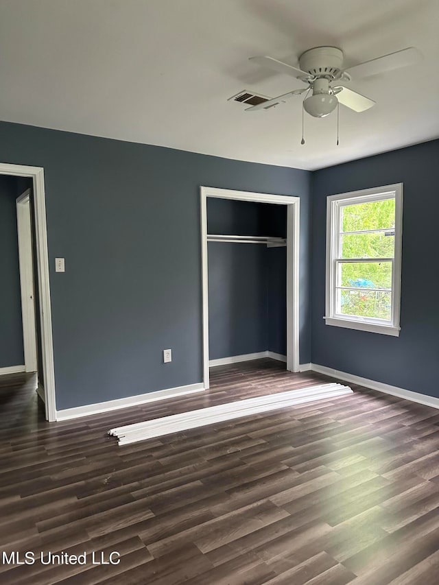 unfurnished bedroom with a closet, ceiling fan, and dark hardwood / wood-style flooring