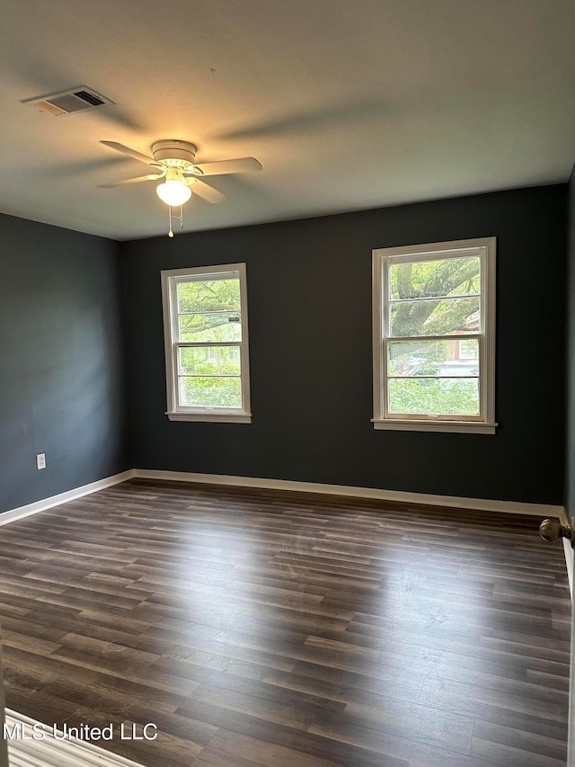 spare room featuring dark wood-type flooring and ceiling fan