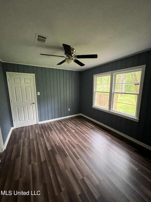 unfurnished room with ceiling fan, a textured ceiling, and dark hardwood / wood-style floors