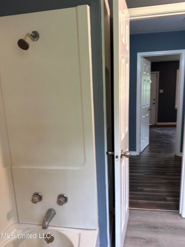 bathroom with shower / washtub combination and hardwood / wood-style floors