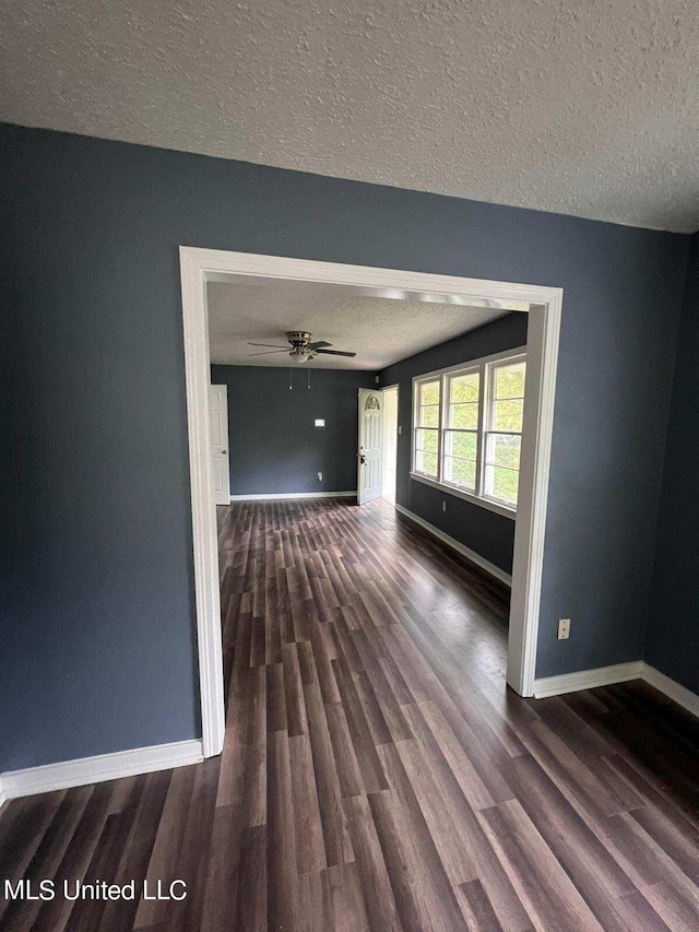 interior space with dark wood-type flooring, ceiling fan, and a textured ceiling