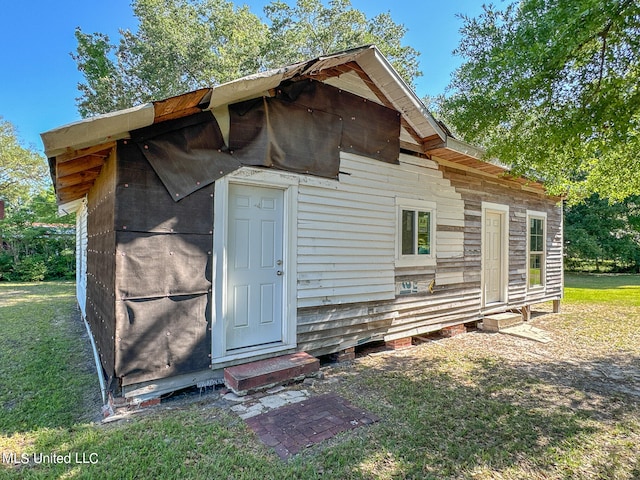 back of property featuring a yard