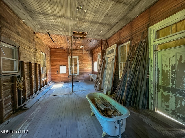 interior space with hardwood / wood-style floors and wooden walls