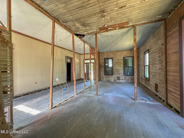 misc room with hardwood / wood-style flooring, wooden ceiling, and brick wall