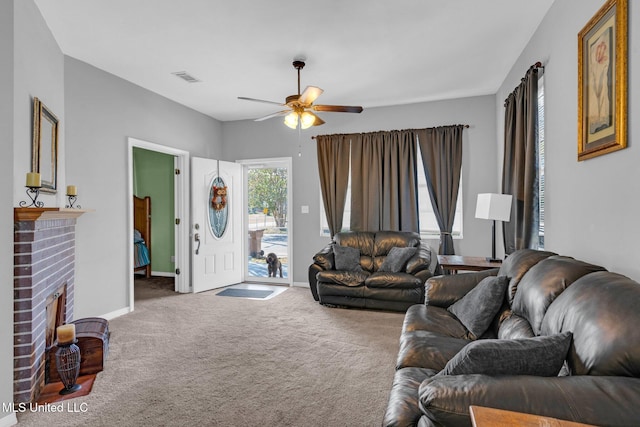 carpeted living room featuring a brick fireplace and ceiling fan