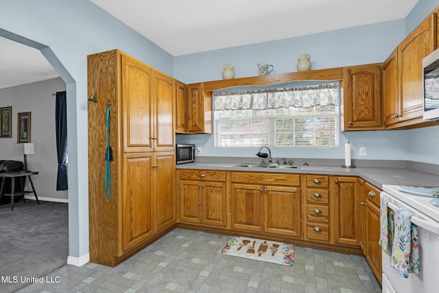 kitchen featuring stainless steel microwave, sink, and white range