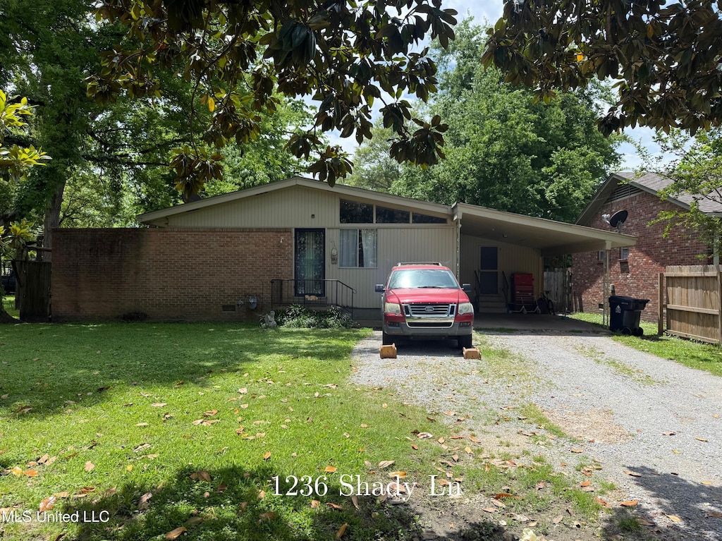 view of front facade featuring driveway, an attached carport, and brick siding