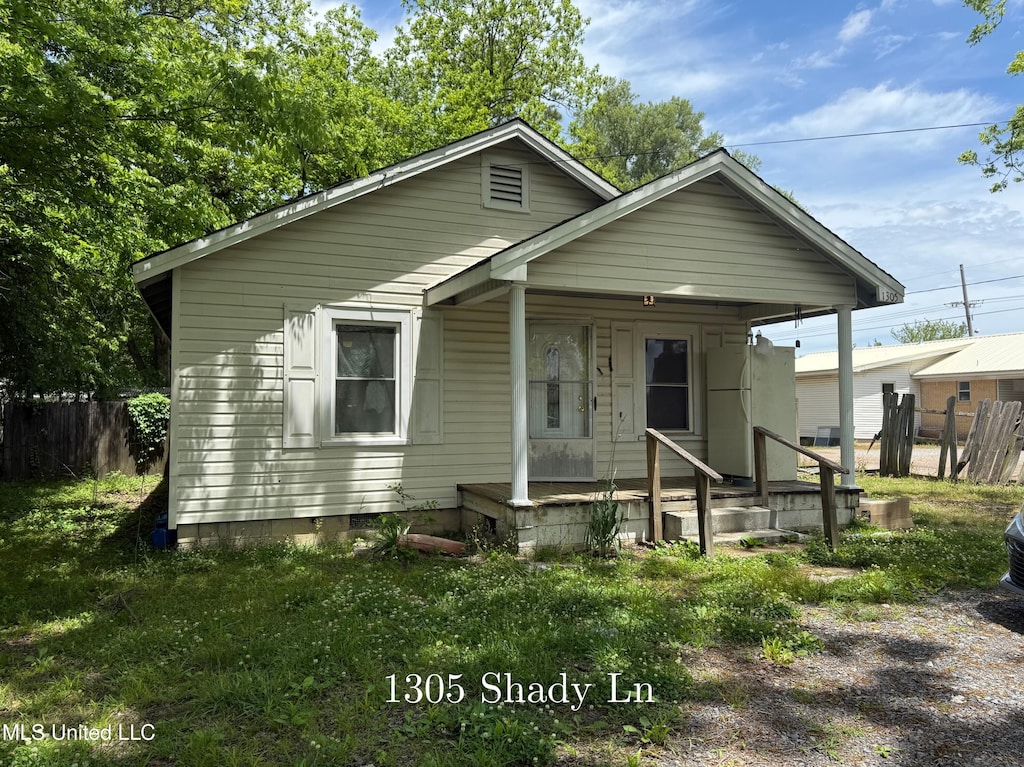 view of front of property featuring a porch and fence