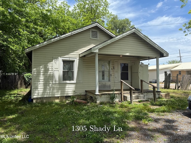 view of front of property featuring a porch and fence