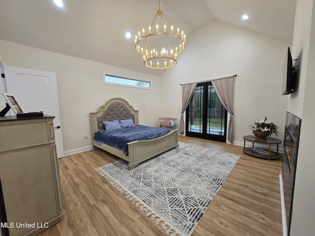 bedroom with high vaulted ceiling, an inviting chandelier, access to exterior, and light wood-style floors