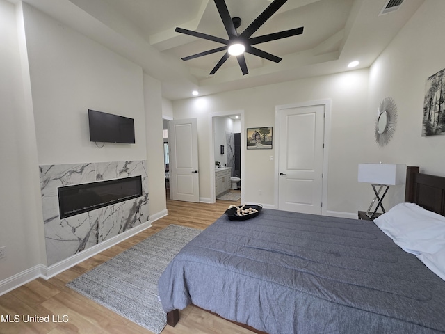 bedroom featuring visible vents, wood finished floors, recessed lighting, and a high end fireplace