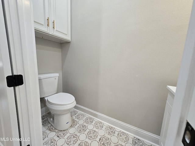 bathroom with baseboards, vanity, and toilet