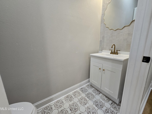 bathroom featuring vanity, toilet, and baseboards
