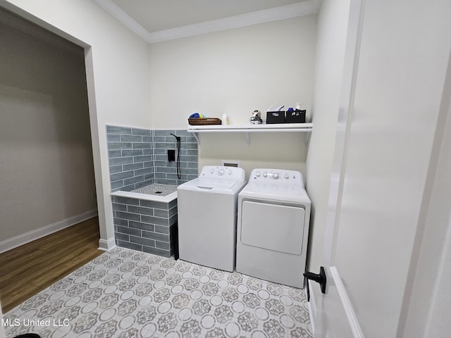 washroom featuring wood finished floors, baseboards, ornamental molding, laundry area, and independent washer and dryer