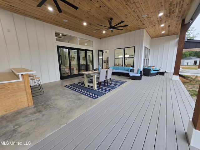 wooden deck featuring outdoor lounge area and ceiling fan