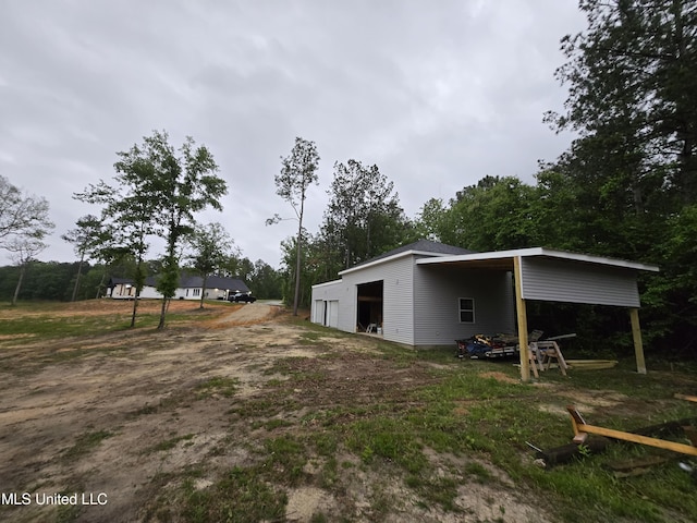 view of yard featuring an outdoor structure, a detached garage, and an outbuilding