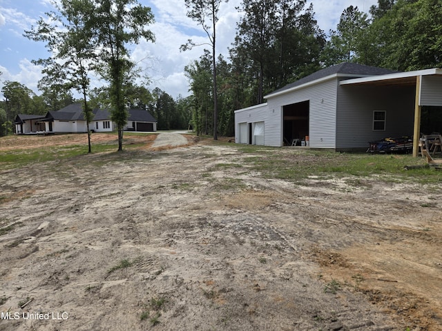 view of yard with driveway, an outbuilding, and a garage