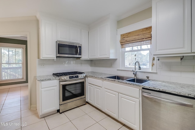 kitchen with stainless steel appliances, sink, and white cabinets