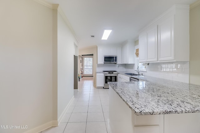 kitchen featuring light stone counters, appliances with stainless steel finishes, kitchen peninsula, and white cabinets