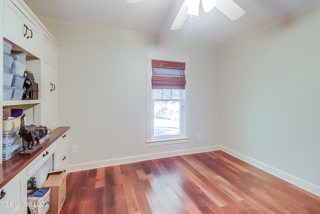 empty room featuring dark wood-type flooring, ornamental molding, and ceiling fan