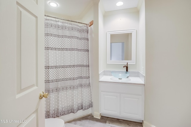 full bathroom featuring shower / tub combo with curtain, hardwood / wood-style flooring, vanity, ornamental molding, and toilet