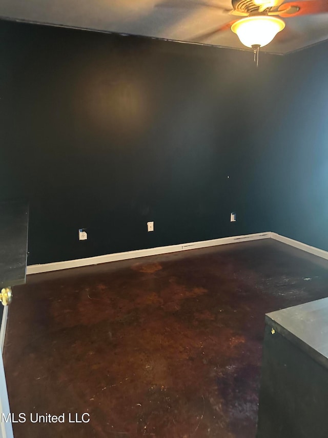 unfurnished room featuring ceiling fan and concrete flooring