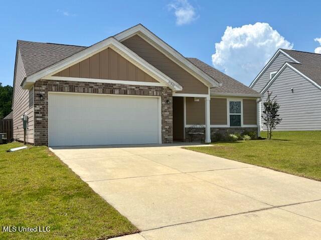 14840 Audubon Lake Blvd, Gulfport, MS 39503 - craftsman house featuring an attached garage, driveway, a front yard, brick siding, and board and batten siding
