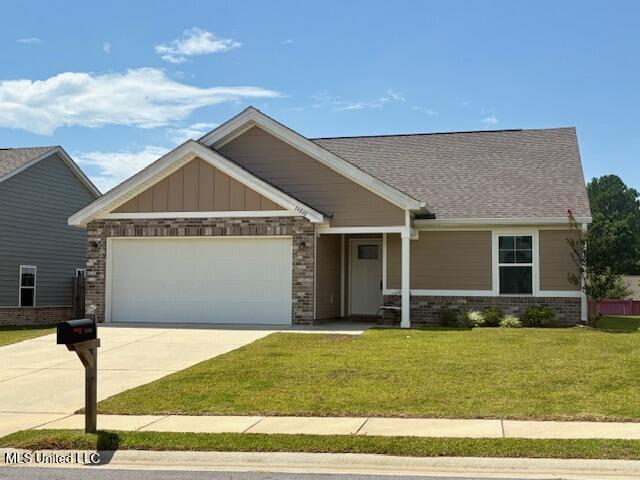 14840 Audubon Lake Blvd, Gulfport, MS 39503 - craftsman-style home with brick siding, a garage, concrete driveway, a front lawn, and a shingled roof