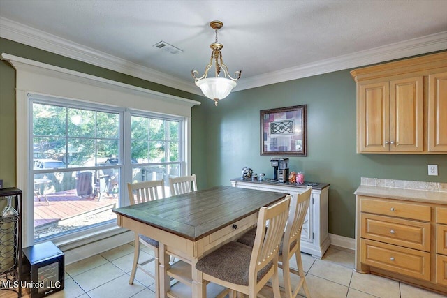 dining area featuring ornamental molding and light tile patterned floors