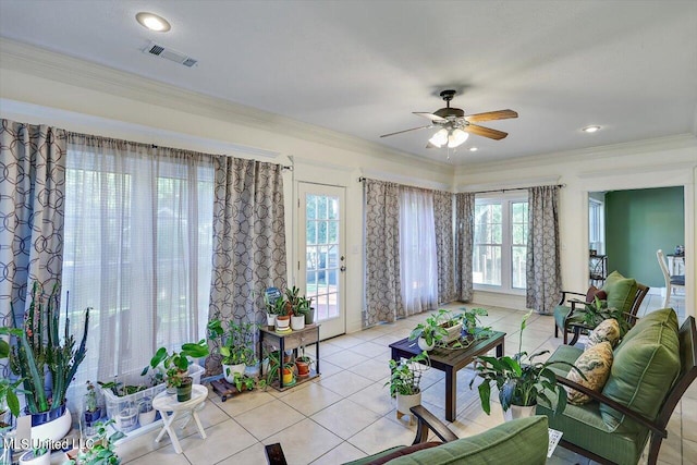 tiled living room featuring ceiling fan, ornamental molding, and plenty of natural light