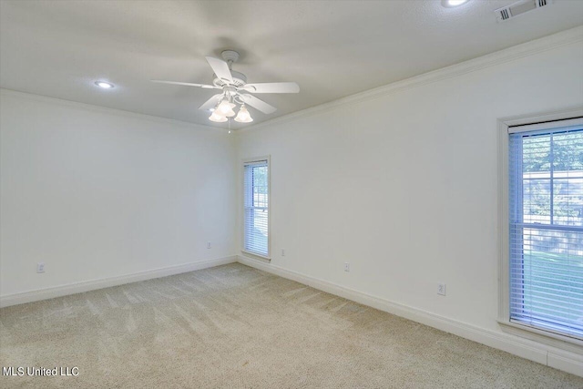 carpeted empty room featuring ornamental molding, a healthy amount of sunlight, and ceiling fan