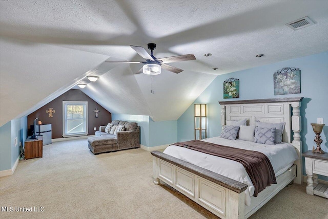 carpeted bedroom with ceiling fan, a textured ceiling, and vaulted ceiling