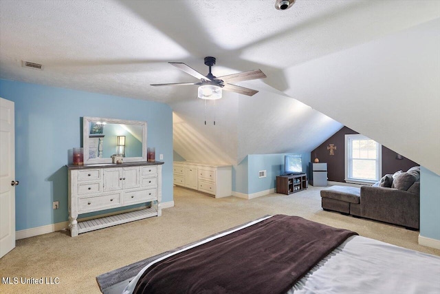 bedroom featuring ceiling fan, light carpet, a textured ceiling, and vaulted ceiling