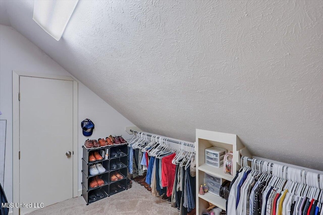 walk in closet featuring lofted ceiling and carpet flooring