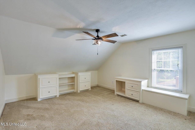 bonus room with light carpet, a textured ceiling, ceiling fan, and vaulted ceiling