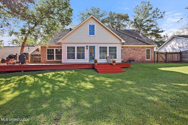 back of property featuring a wooden deck and a lawn