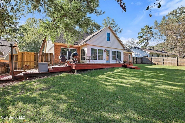 rear view of house featuring a deck and a lawn