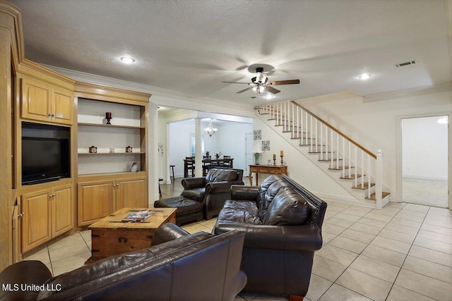 tiled living room featuring crown molding, a textured ceiling, ceiling fan with notable chandelier, and built in shelves