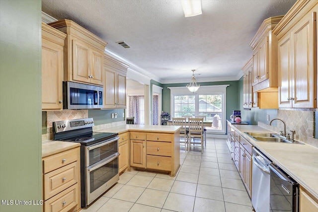 kitchen featuring light brown cabinets, kitchen peninsula, hanging light fixtures, sink, and appliances with stainless steel finishes