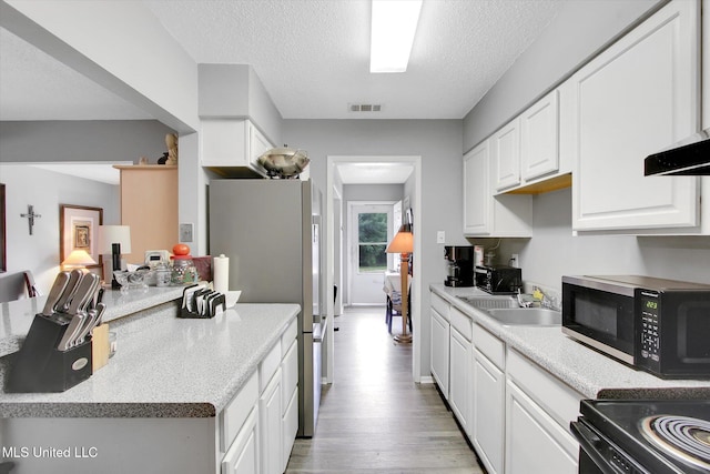 15820 Big Ridge Rd, Biloxi, MS 39532 - kitchen with stainless steel appliances, white cabinets, light wood-type flooring, a sink, and light countertops