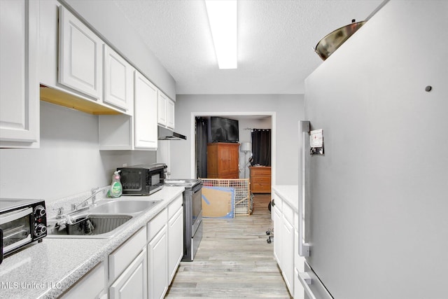 15820 Big Ridge Rd, Biloxi, MS 39532 - kitchen featuring freestanding refrigerator, a sink, under cabinet range hood, range with electric stovetop, and light countertops