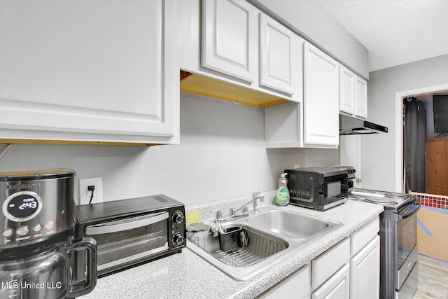 15820 Big Ridge Rd, Biloxi, MS 39532 - kitchen featuring electric range oven, black microwave, a sink, under cabinet range hood, and white cabinets