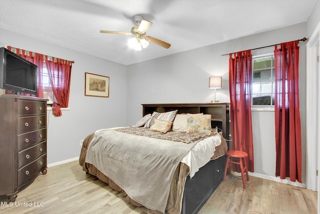 15820 Big Ridge Rd, Biloxi, MS 39532 - bedroom with multiple windows, wood finished floors, a ceiling fan, a textured ceiling, and baseboards