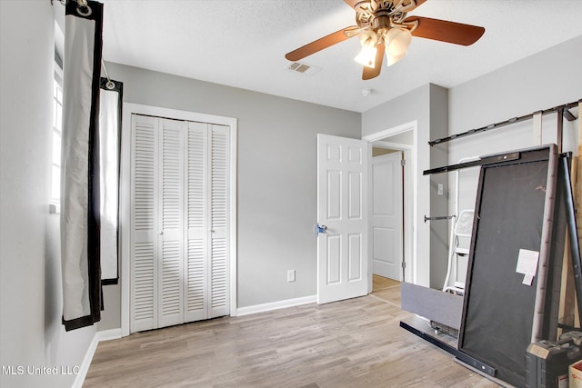 15820 Big Ridge Rd, Biloxi, MS 39532 - unfurnished bedroom with wood finished floors, baseboards, a closet, and a ceiling fan