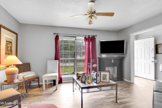 15820 Big Ridge Rd, Biloxi, MS 39532 - living room with ceiling fan, wood finished floors, a textured ceiling, baseboards, and a fireplace
